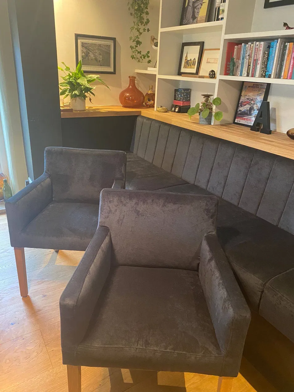 Grey velvet chairs with matching banquette seating and shelving