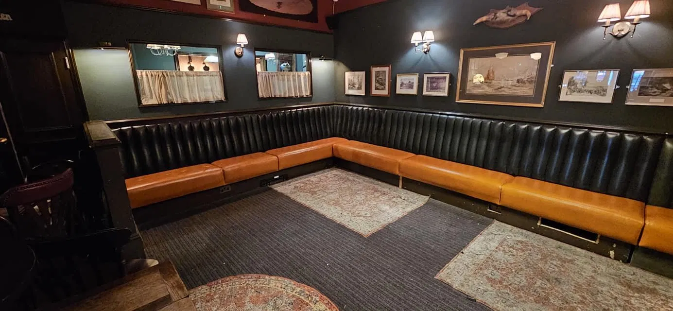 Dark L-shaped pub banquette with tan leather seats