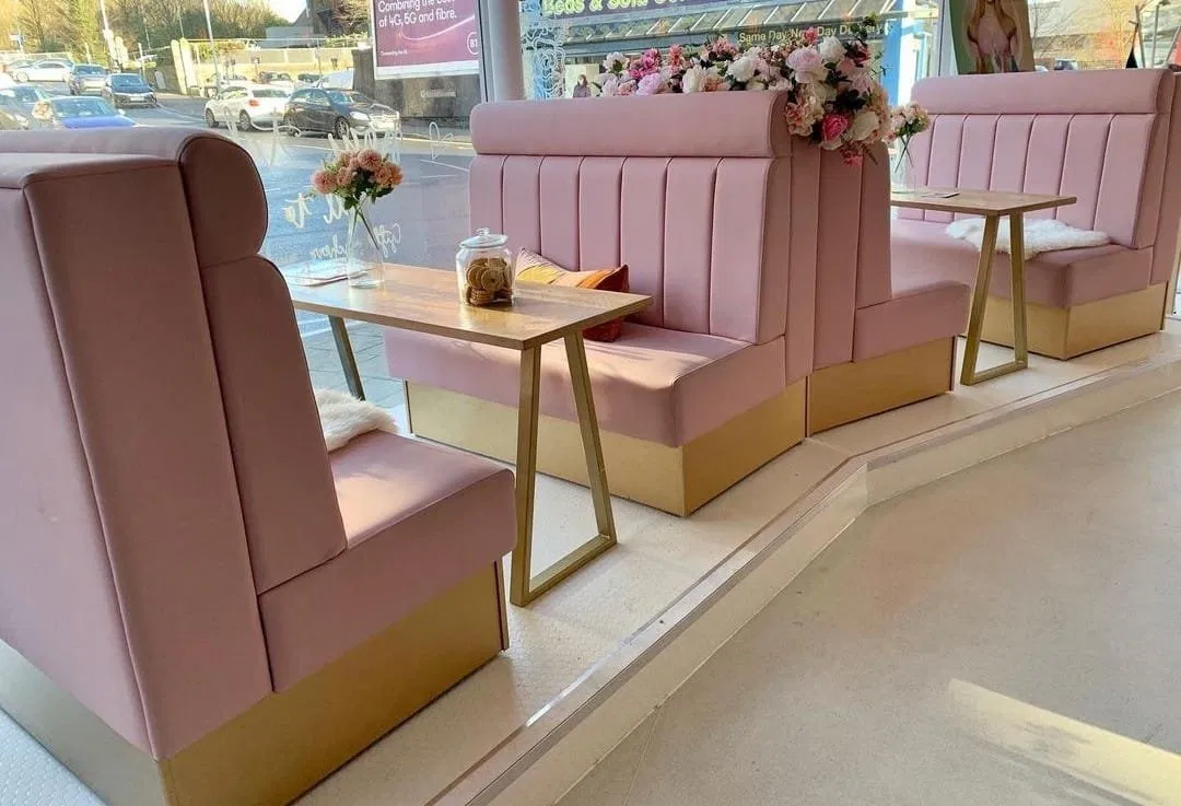 Pink channel-stitched cafe booths with gold bases