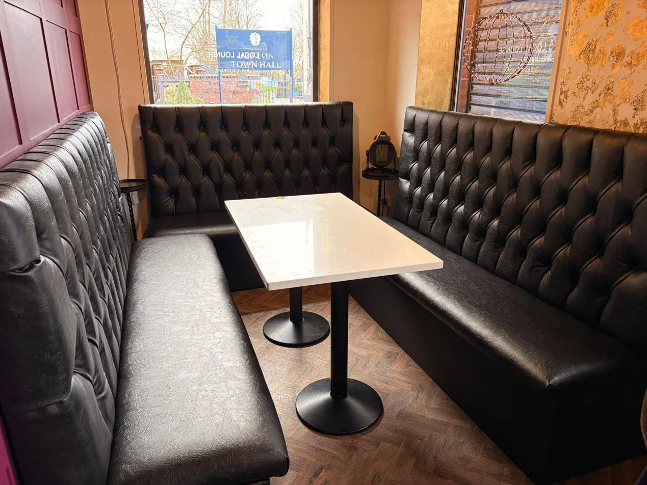 Black chesterfield booth seating facing each other