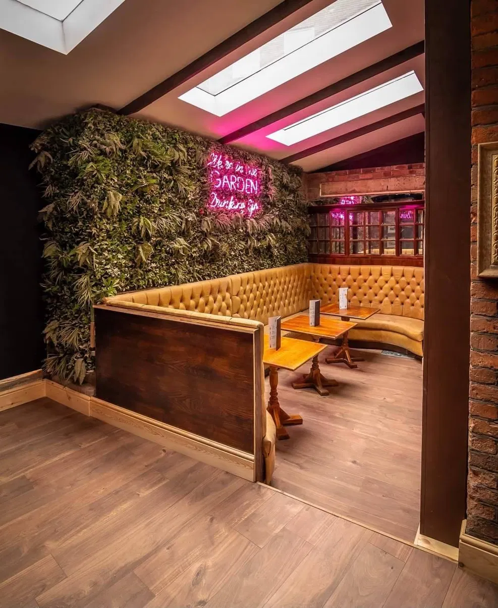 Curved gold chesterfield booth seating with neon sign